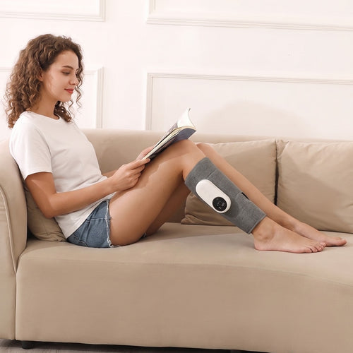 Woman reading on the sofa with a heated calf massager